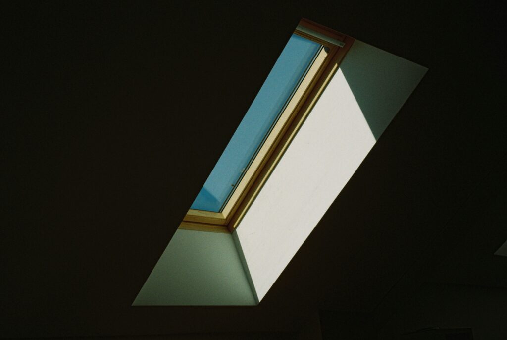 roof lantern surrounded by darkness, looking out onto a blue sky