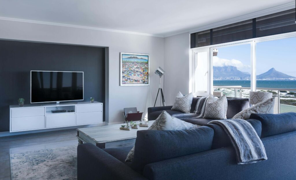 Modern living room with  large glass windows overlooking a lake