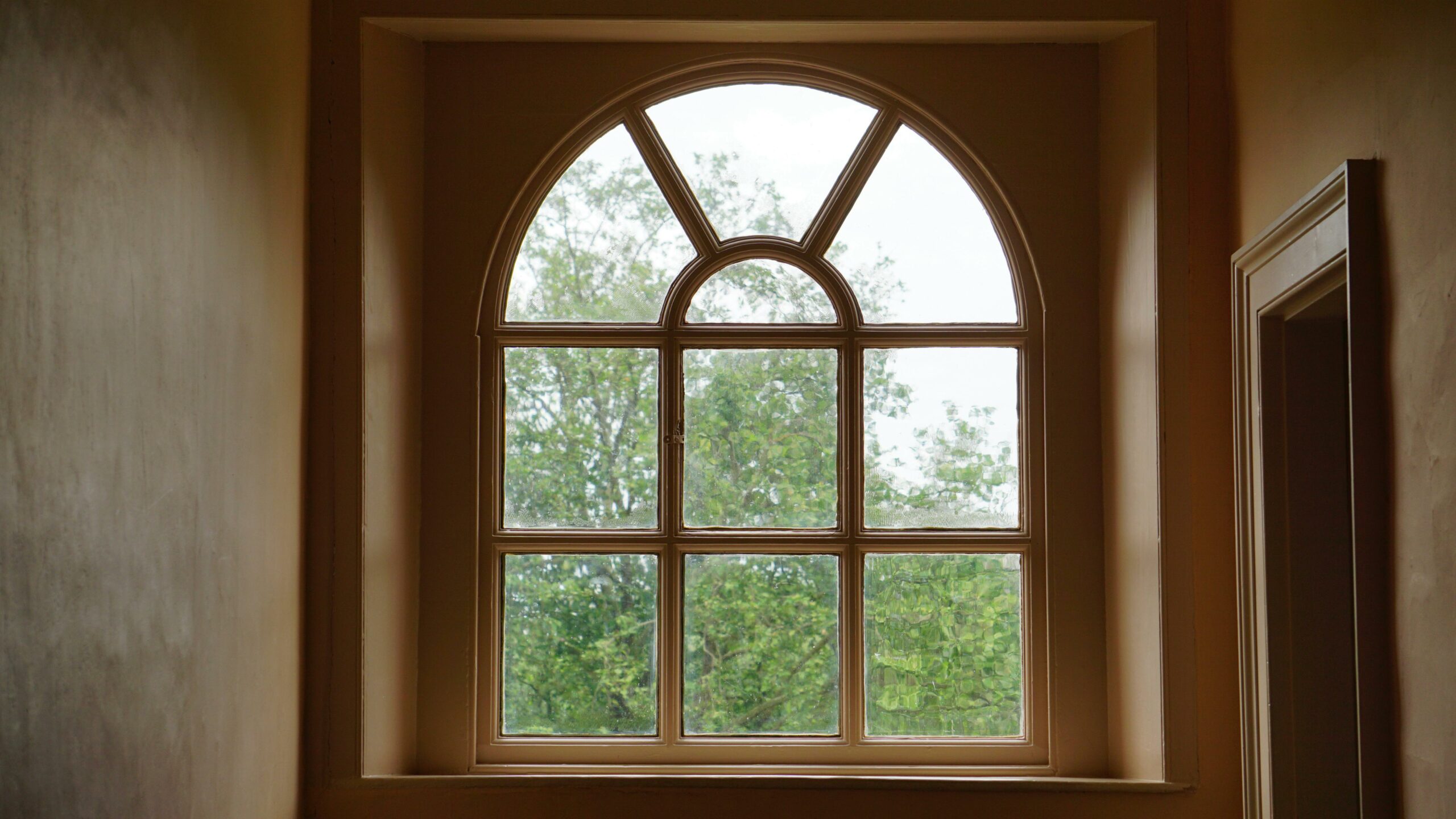 Arched beige wooden window