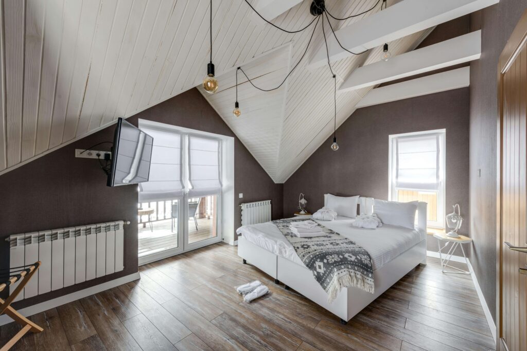 modern attic bedroom with a slanted white wooden ceiling